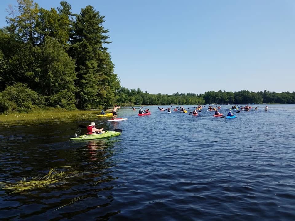 A group kayaks on Great Pond in Kingston New Hampshire