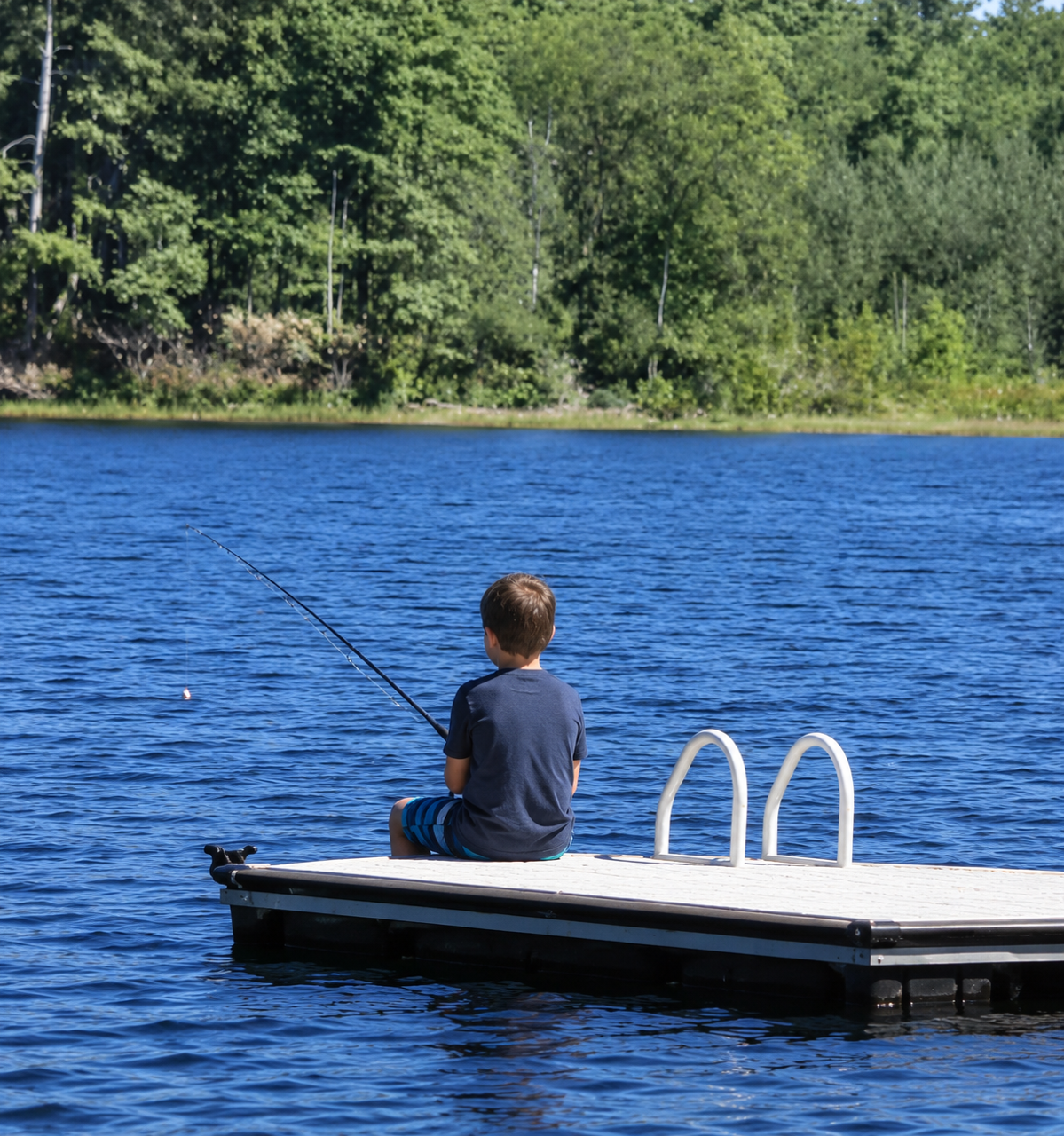 Kid fishing while sitting on a dock at Country Pond in Kingston, NH